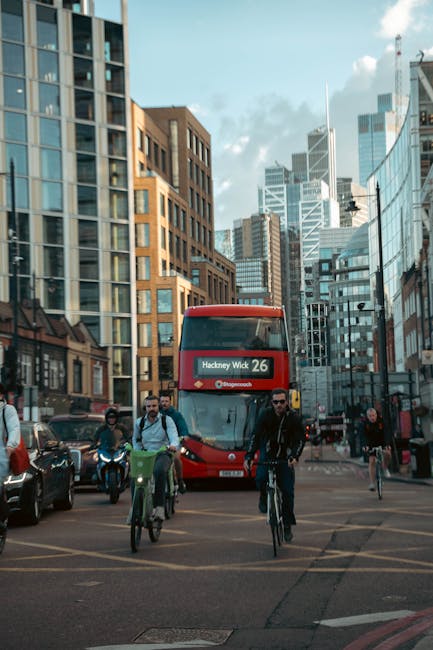 A street sign mounted on a black pole indicating 'Redchurch Street' in the London Borough of Hackney with postal code E2, set against a blurred urban background with buildings and scaffolding. The str